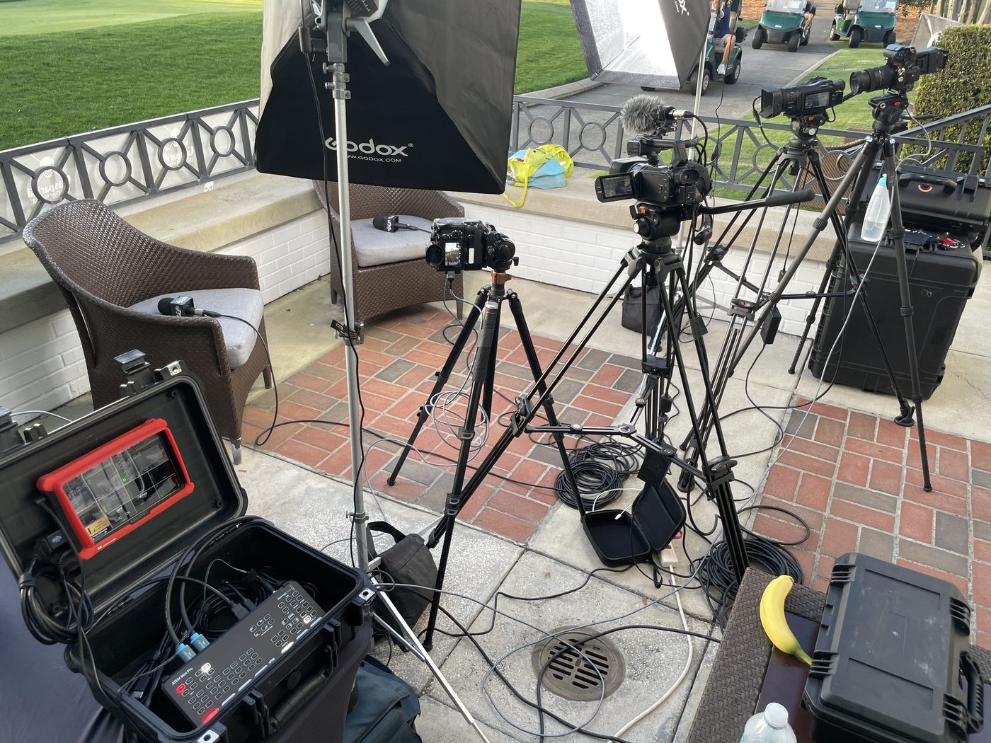 Multi-camera lighting and audio setup at a golf club patio shoot
